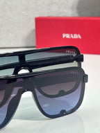 Prada dark rectangular sunglasses with tinted lenses and logo on temple