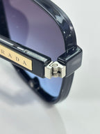 Prada glasses hinge detail with gold logo plate on dark temple