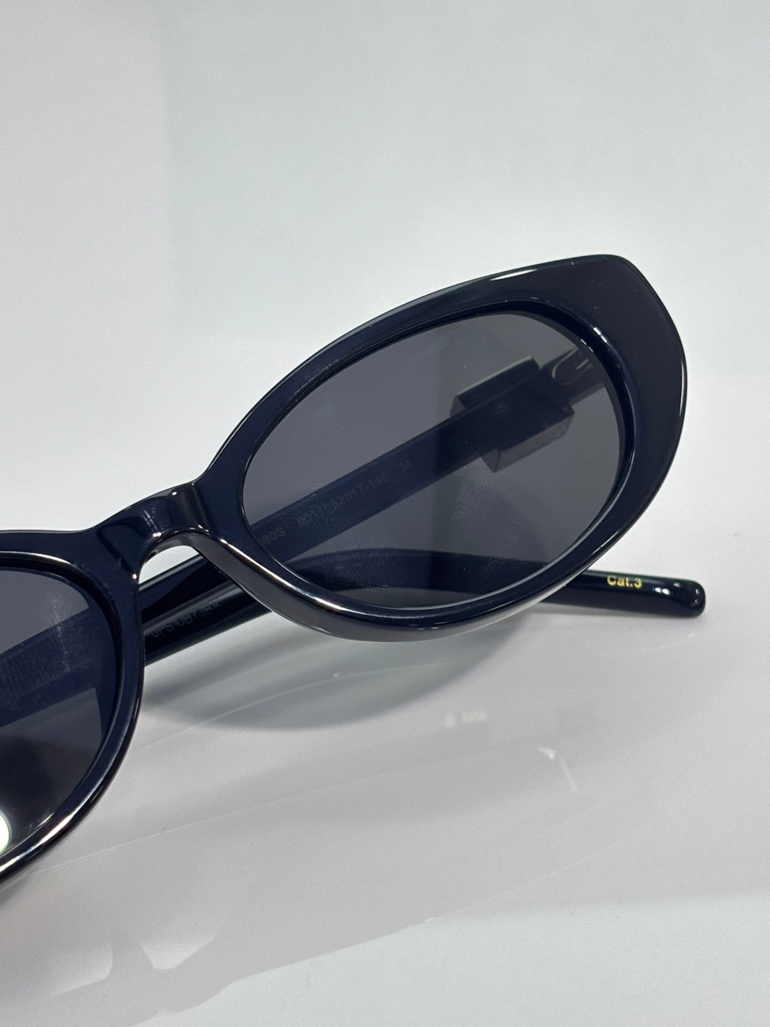 Close-up of dark cat-eye sunglasses lens and temple arm