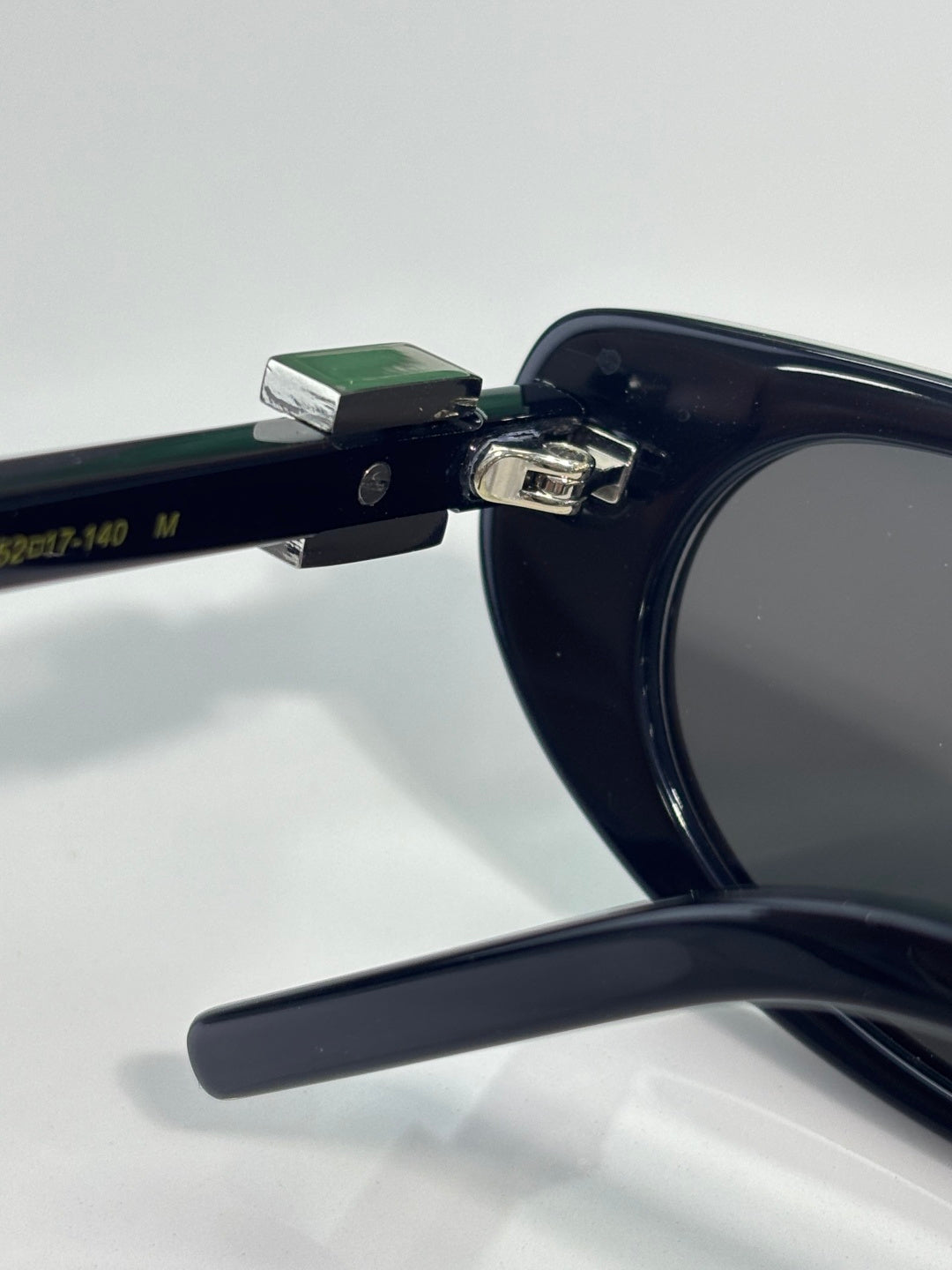 Close-up of sunglasses temple with size markings on dark frame