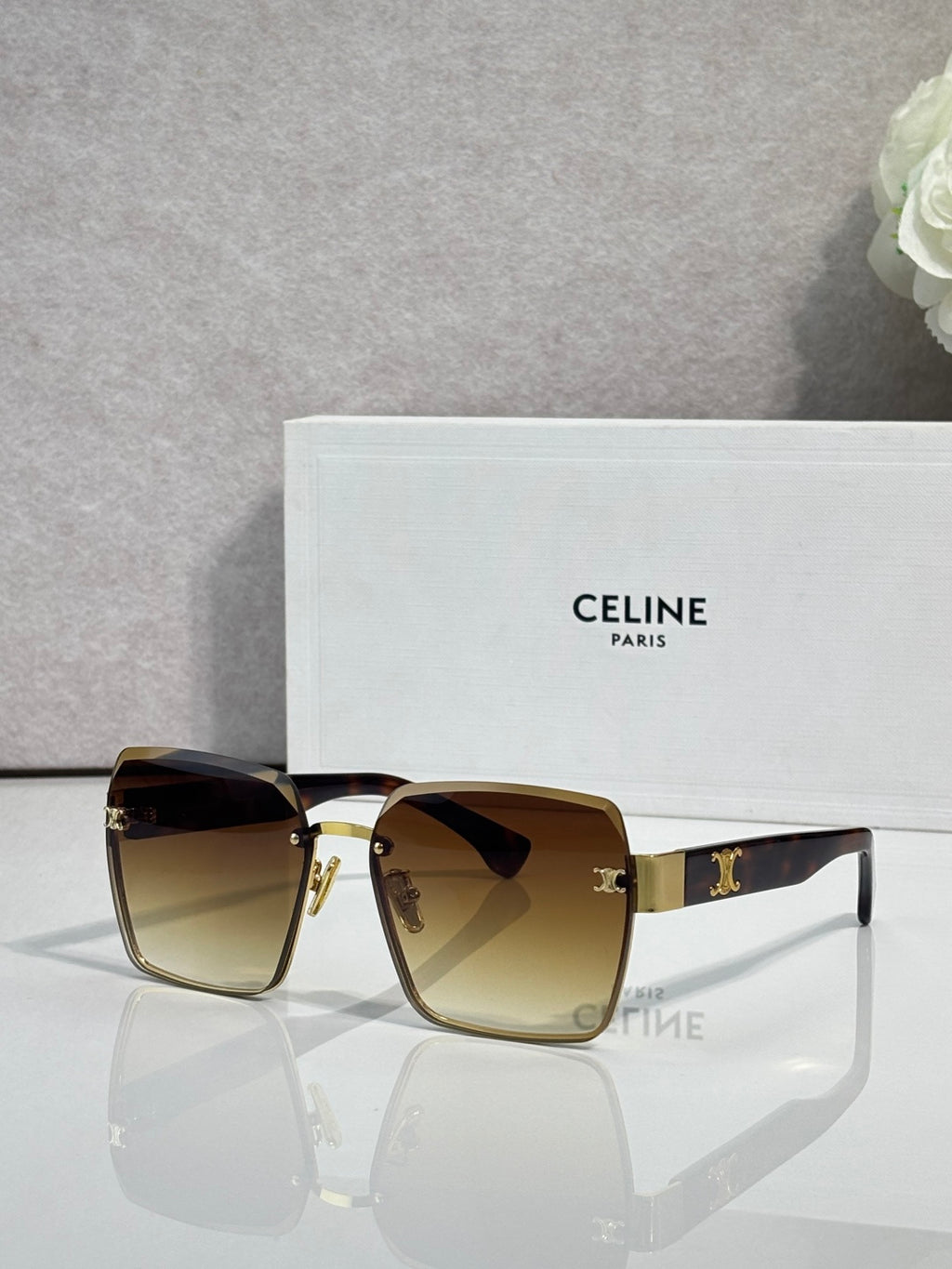 Square sunglasses with gold-tone frame and warm amber gradient lenses