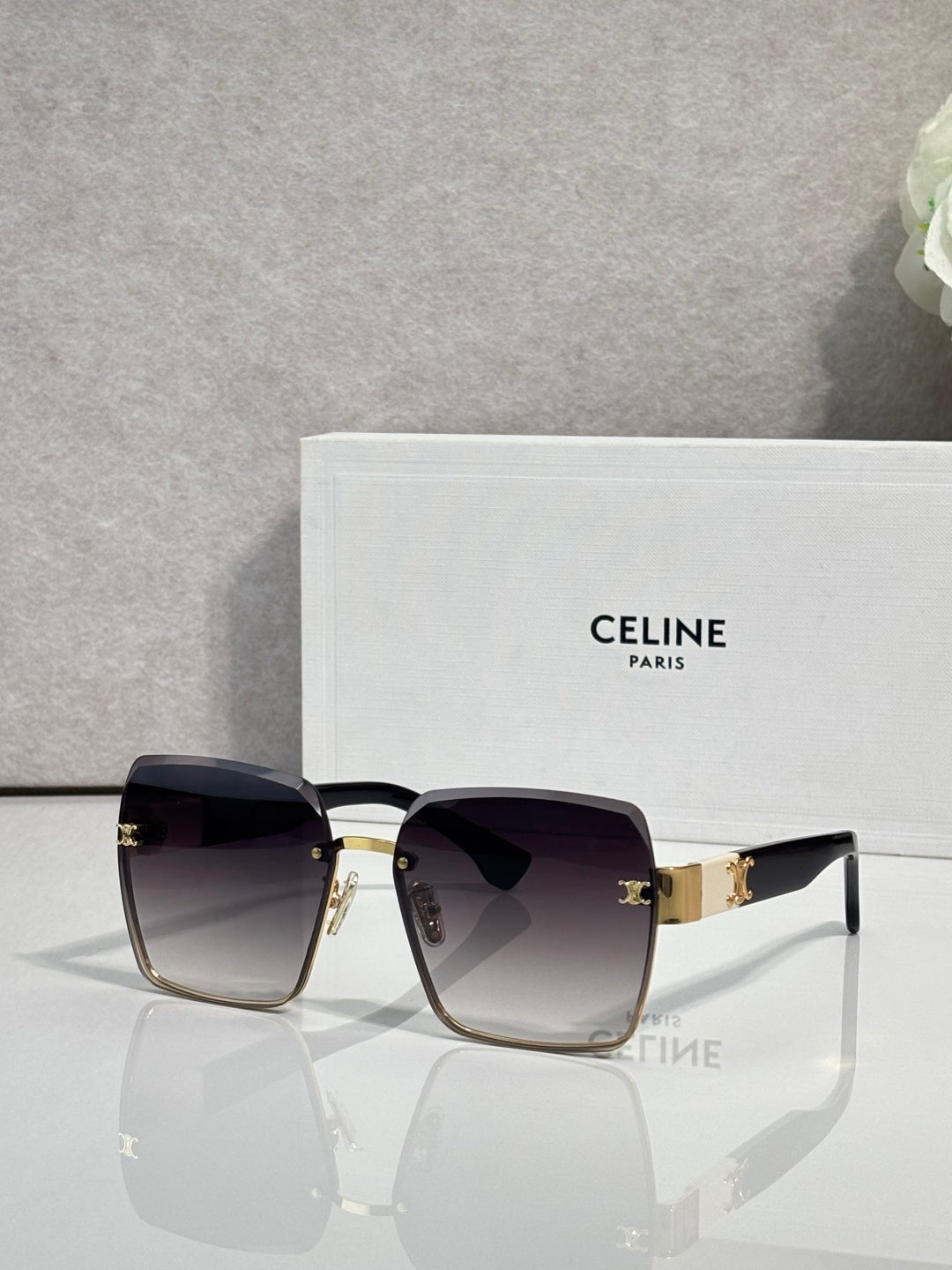 Square sunglasses with gold-tone frame and dark black gradient lenses