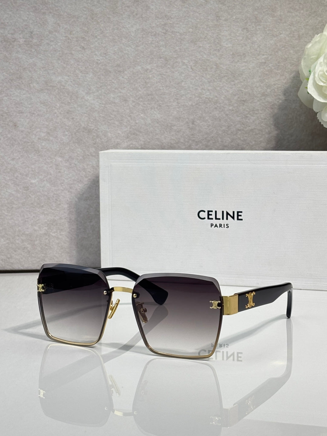 Square sunglasses with gold-tone frame and dark gray gradient lenses