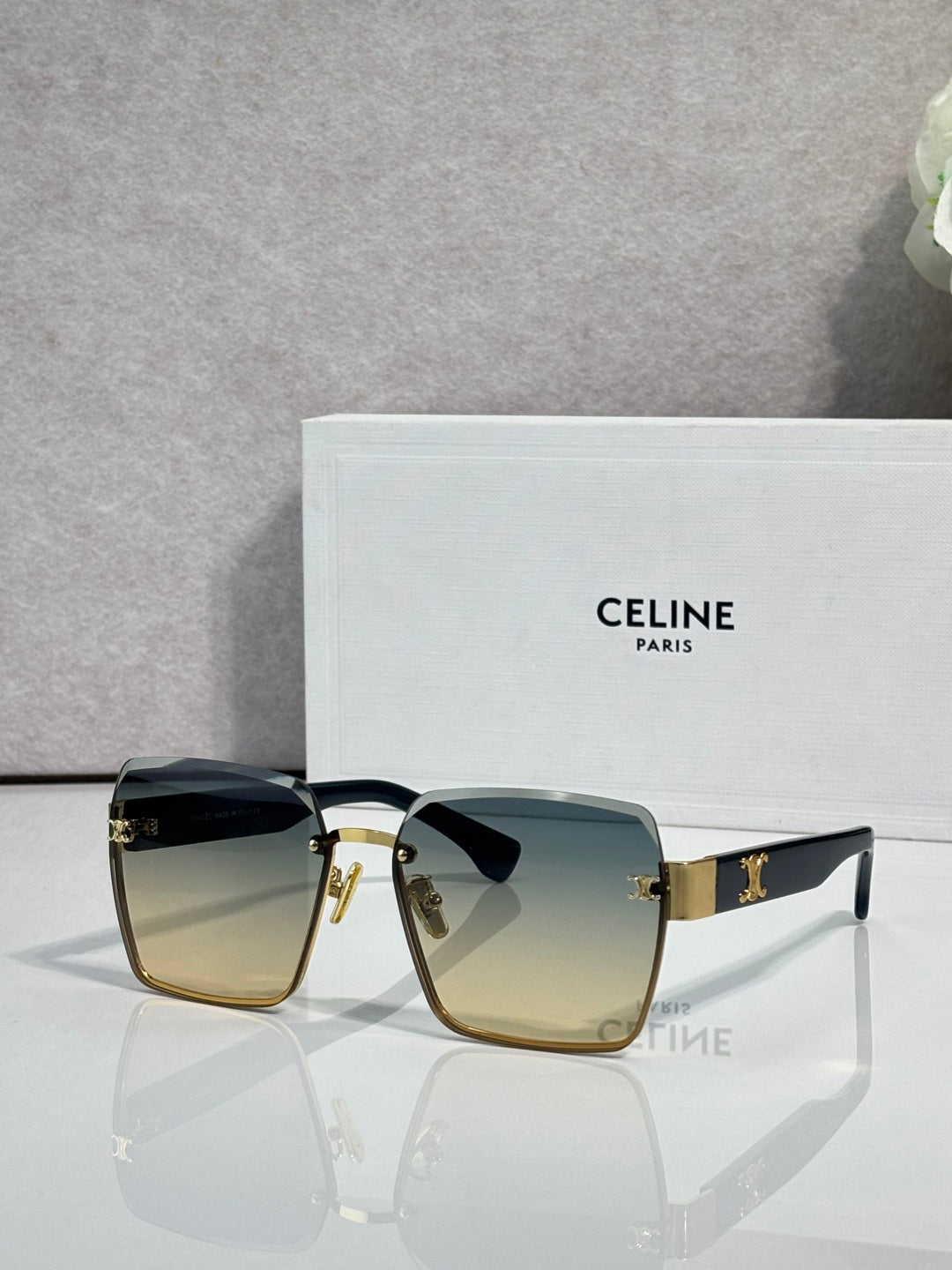 Square sunglasses with gold-tone frame and blue-green gradient lenses