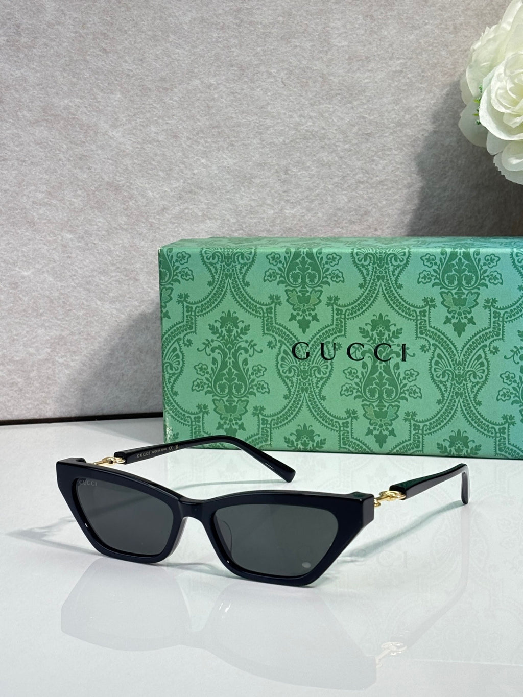 Black cat-eye glasses with dark lenses and gold-tone hinges