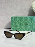 Black cat-eye glasses with dark lenses and gold-tone hinges