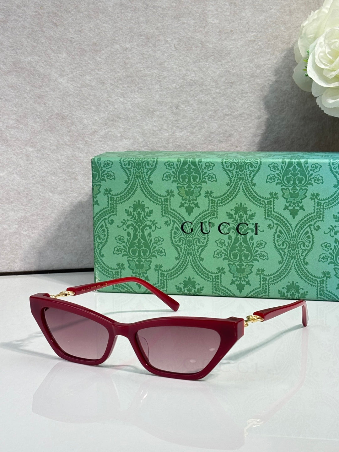 Red cat-eye glasses with pink-tinted lenses and gold-tone hinges