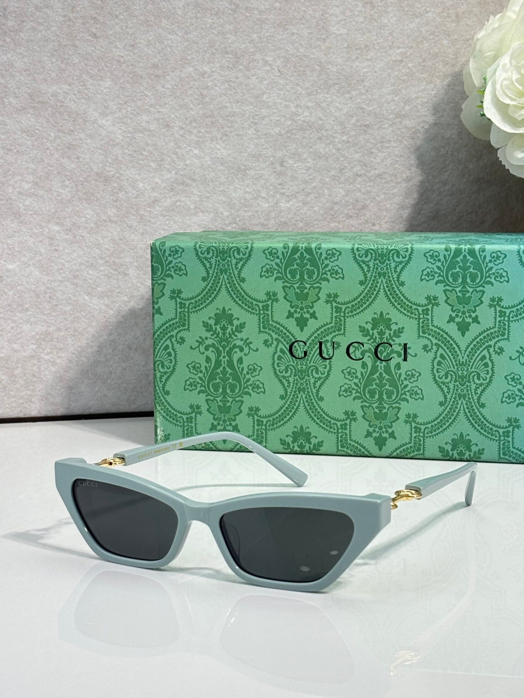 Light blue cat-eye glasses with dark lenses and gold-tone hinges