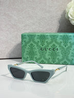 Light blue cat-eye glasses with dark lenses and gold-tone hinges