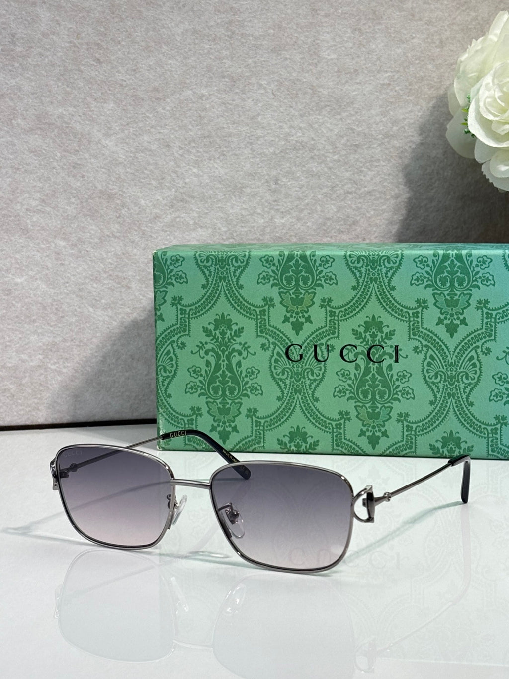 Gucci sunglasses with dark gray lenses and silver frame