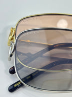 Gucci sunglasses close-up of gold frame and tinted lenses with GUCCI marking
