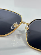 Cartier sunglasses detail: gold bridge and side hinge with dark lens