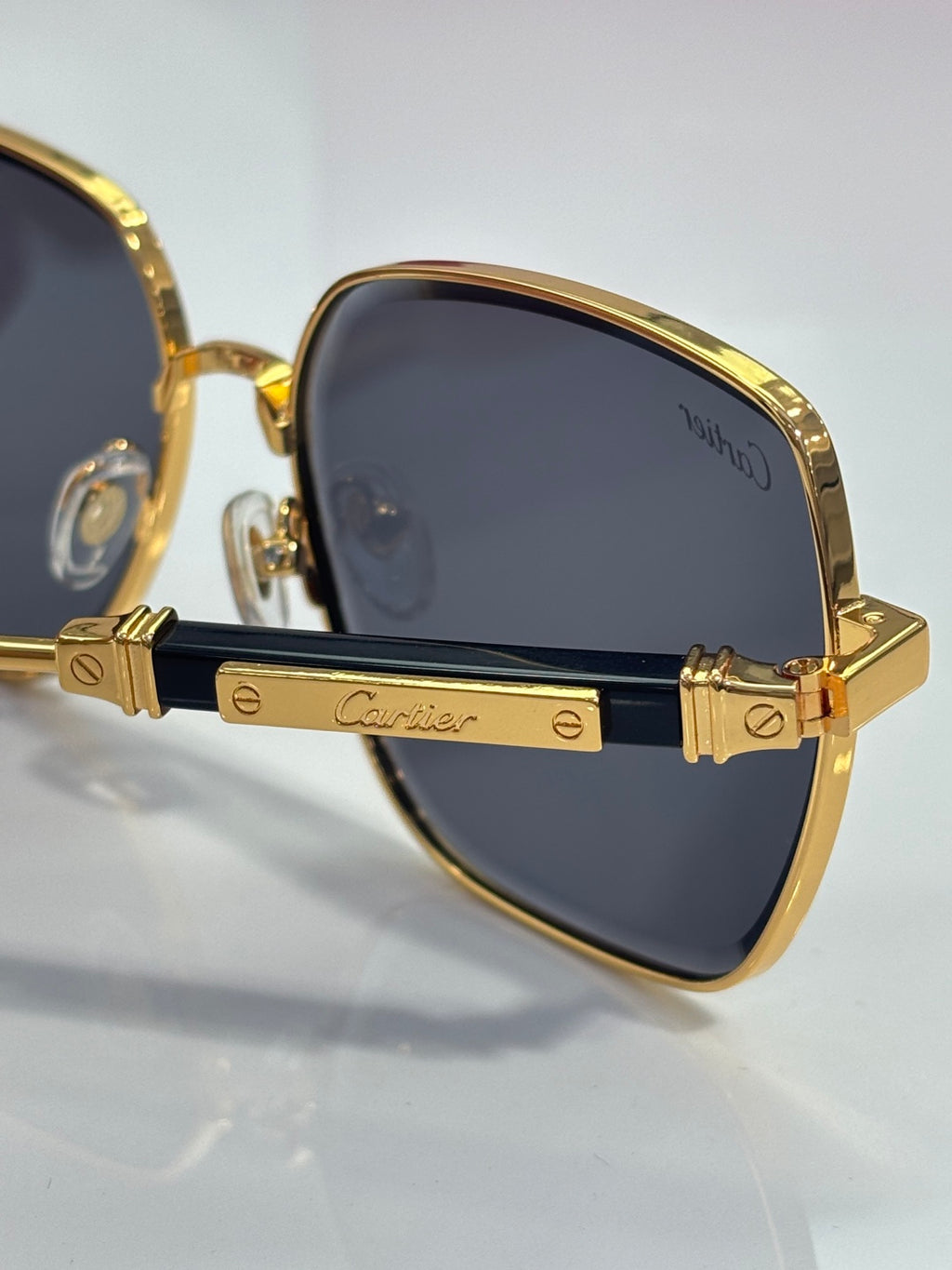 Cartier sunglasses side detail with gold arms and blue front accents