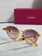 Gold-tone round sunglasses with pink lenses and temple emblem detail