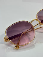 Gold-tone round sunglasses with purple-tinted lens and Cartier engraving