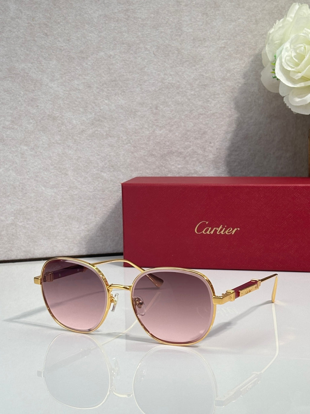 Gold-tone round sunglasses with mauve tinted lenses and thin arms