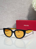 Prada cat-eye sunglasses with black frame and amber-tinted lenses