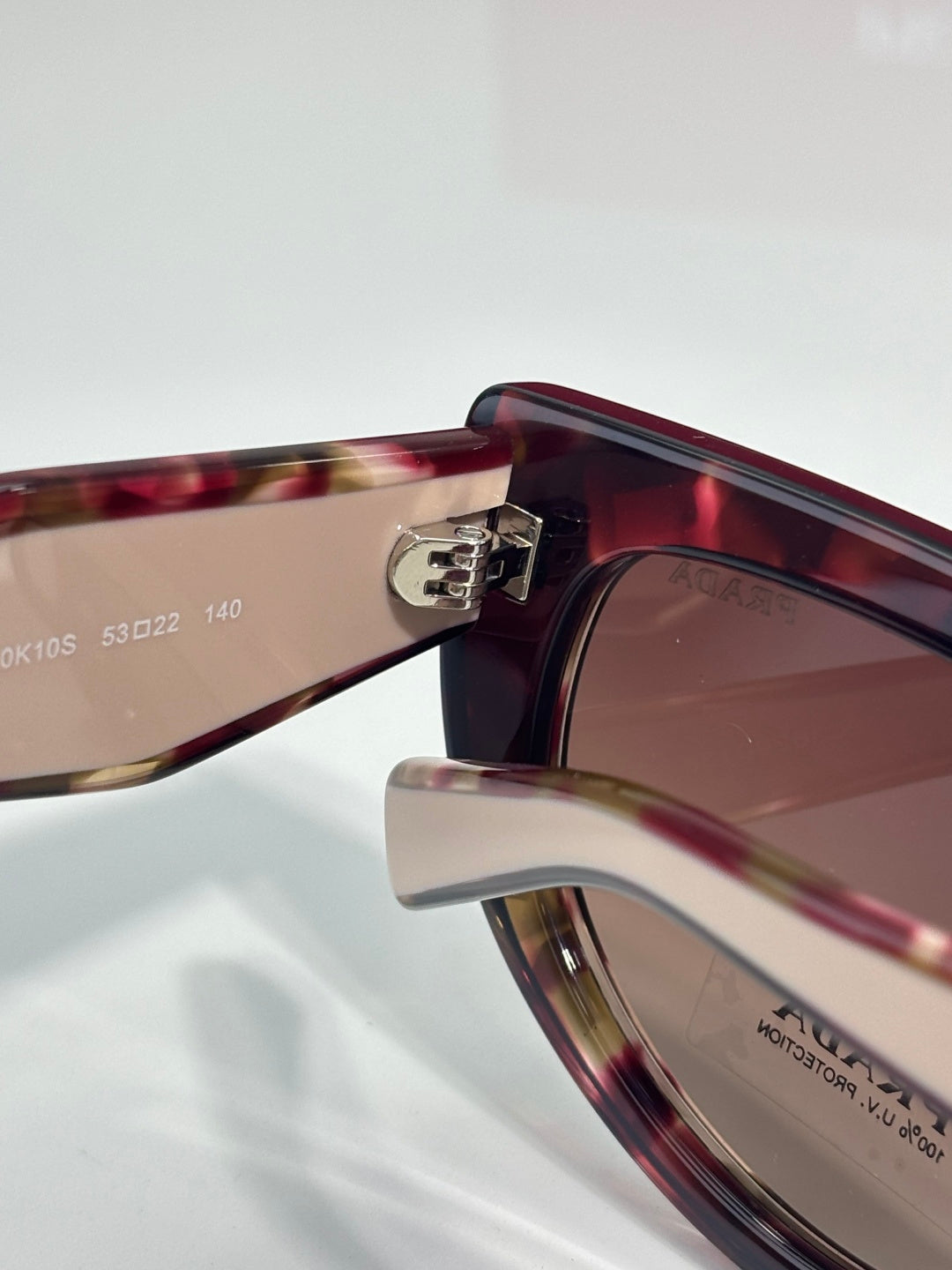 Cat-eye sunglasses close-up of tortoiseshell temple and logo bridge