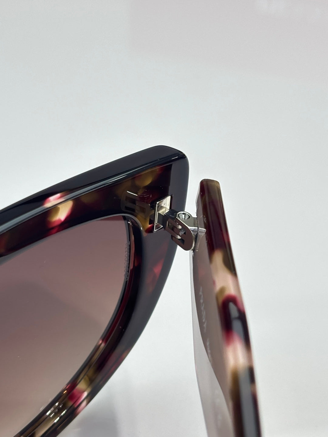 Cat-eye sunglasses close-up of tortoiseshell frame and metal hinge