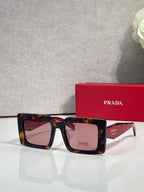 Prada sunglasses, tortoiseshell frames with brown gradient lenses and logo temple.