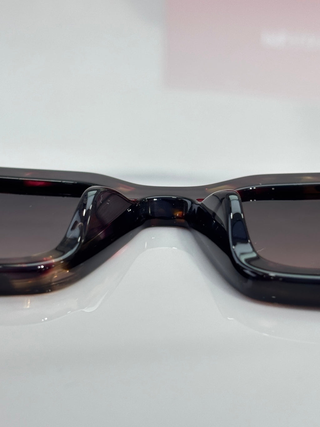 Prada sunglasses close-up: black frame bridge and curved dark lenses.