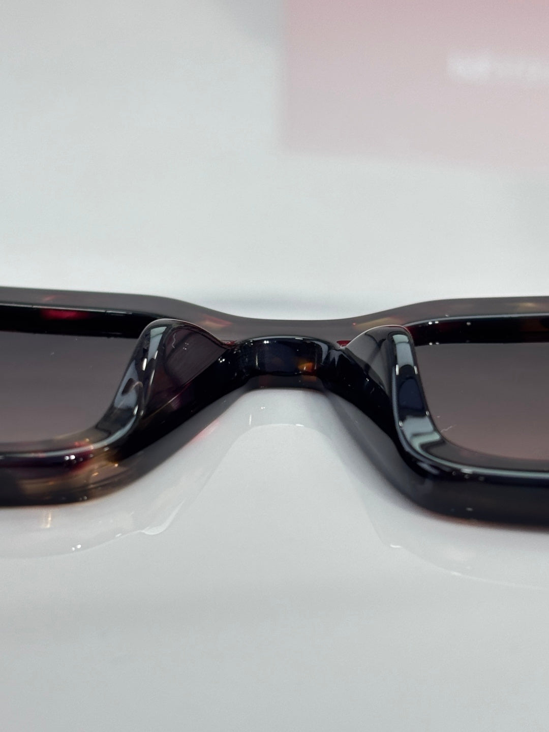 Prada sunglasses close-up: black frame bridge and curved dark lenses.