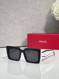Prada sunglasses, black square frames with dark lenses and logoed arms.