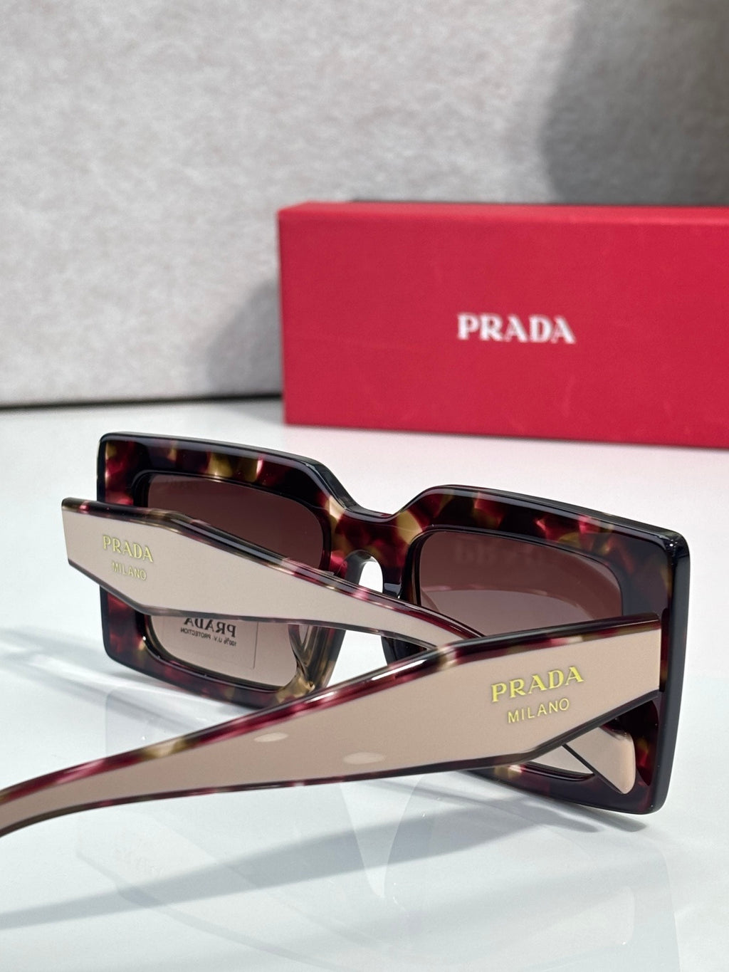 Prada sunglasses, tortoiseshell frames with brown lenses and Prada lettering on temple.