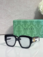Gucci square sunglasses with black frame and dark lenses, gold logo detail