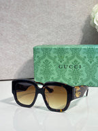 Gucci square sunglasses with dark frame and amber gradient lenses, gold logo
