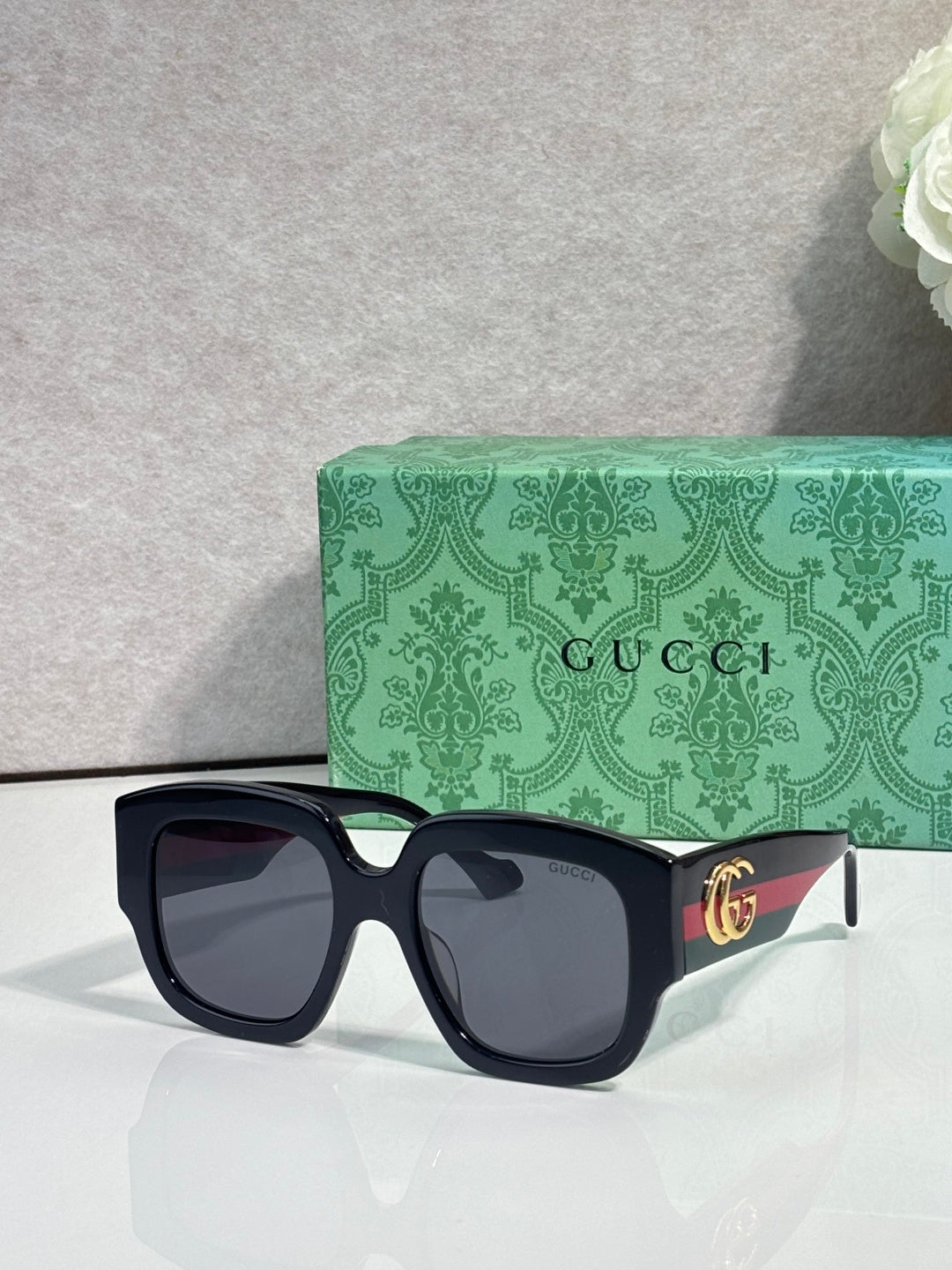 Gucci square sunglasses with dark frame and black lenses, gold logo detail