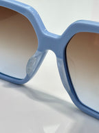Light blue square sunglasses frame close-up with dark lens edge