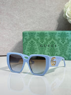 Gucci light blue square sunglasses with gold logo on temples and tinted lenses