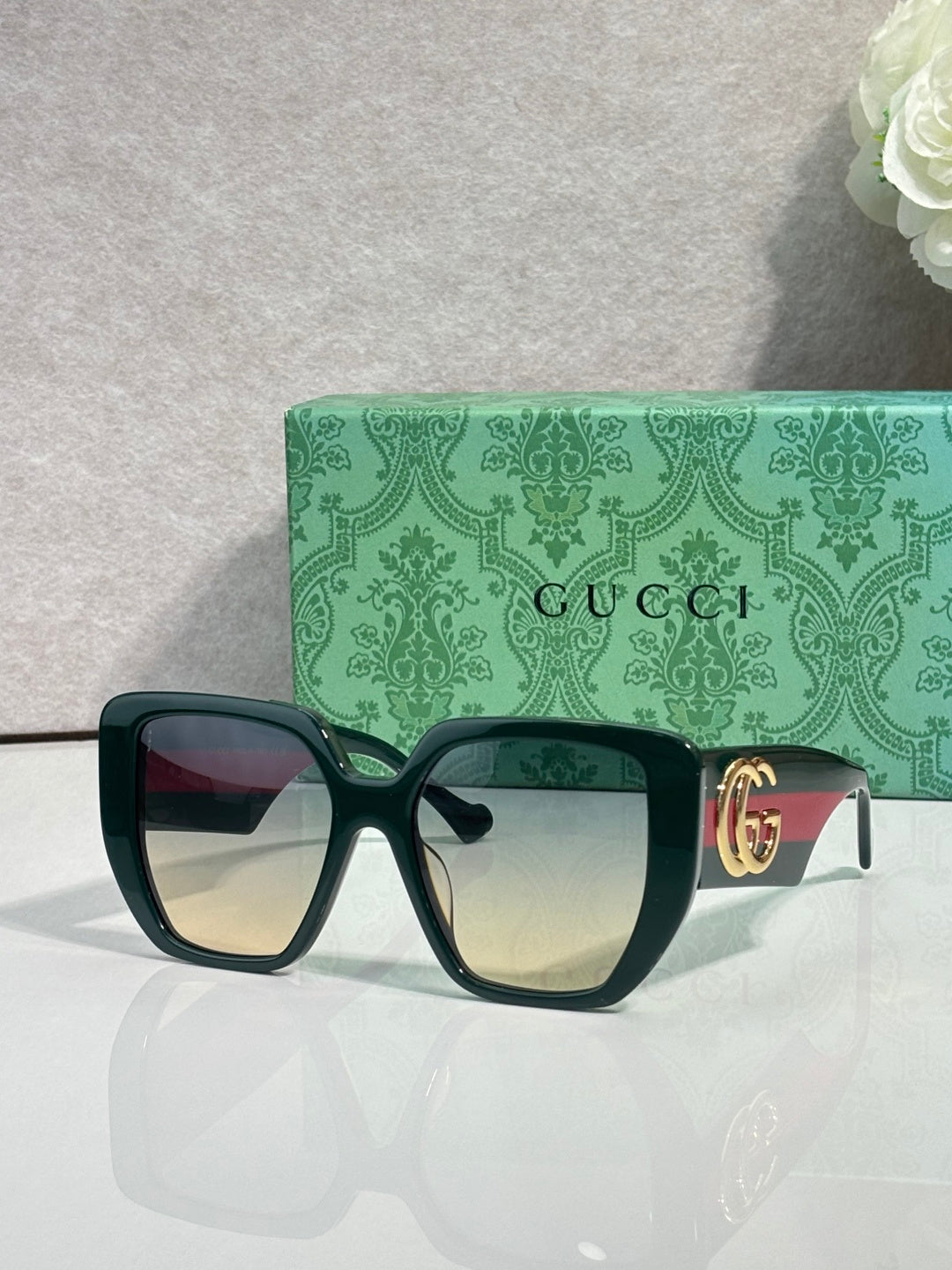 Gucci black square sunglasses with gold logo temple detail and amber-tinted lenses