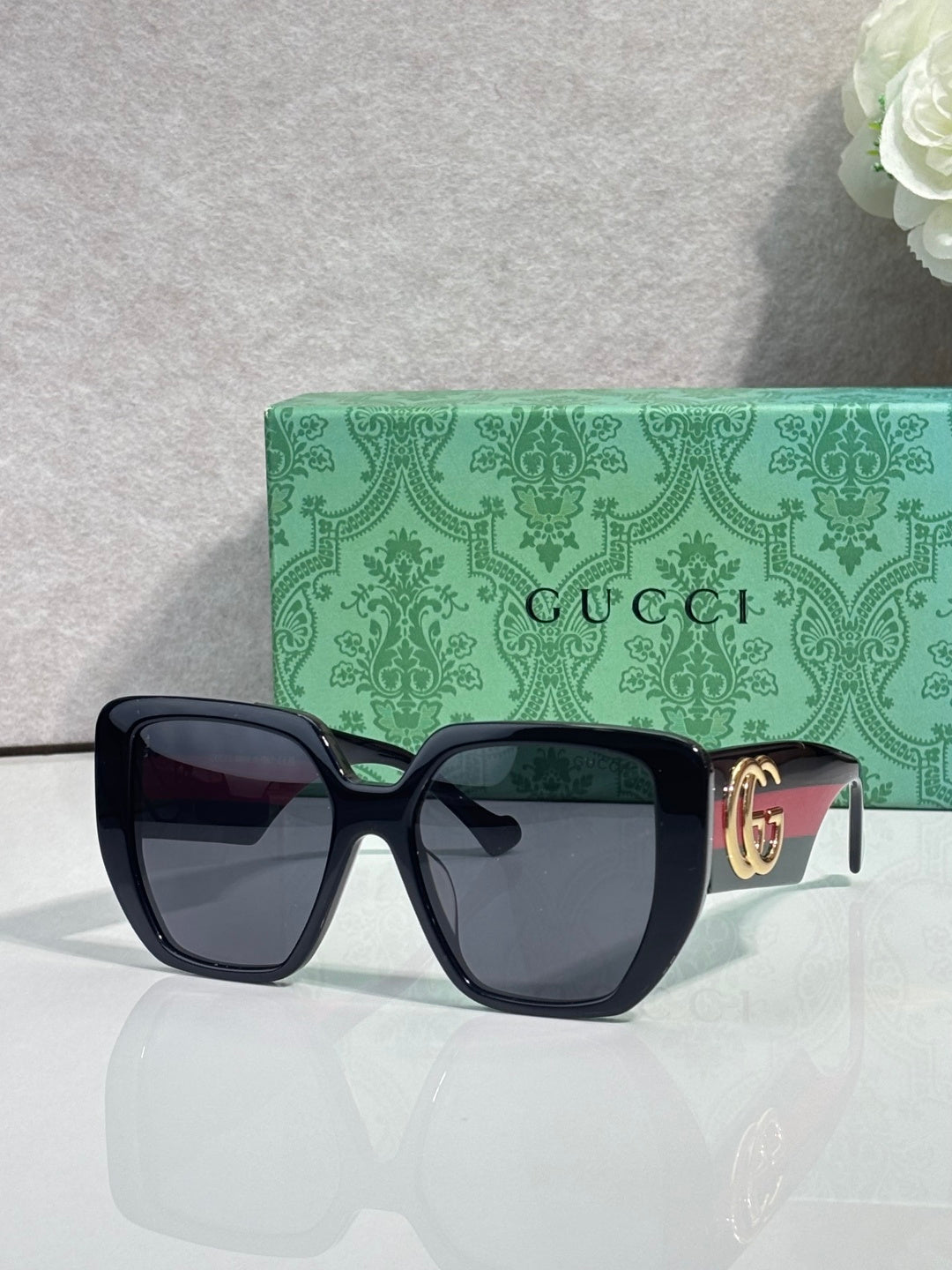 Gucci dark green square sunglasses with gold logo temple detail and dark lenses