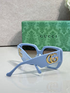 Gucci light blue square sunglasses with gold logo temple and tinted lenses