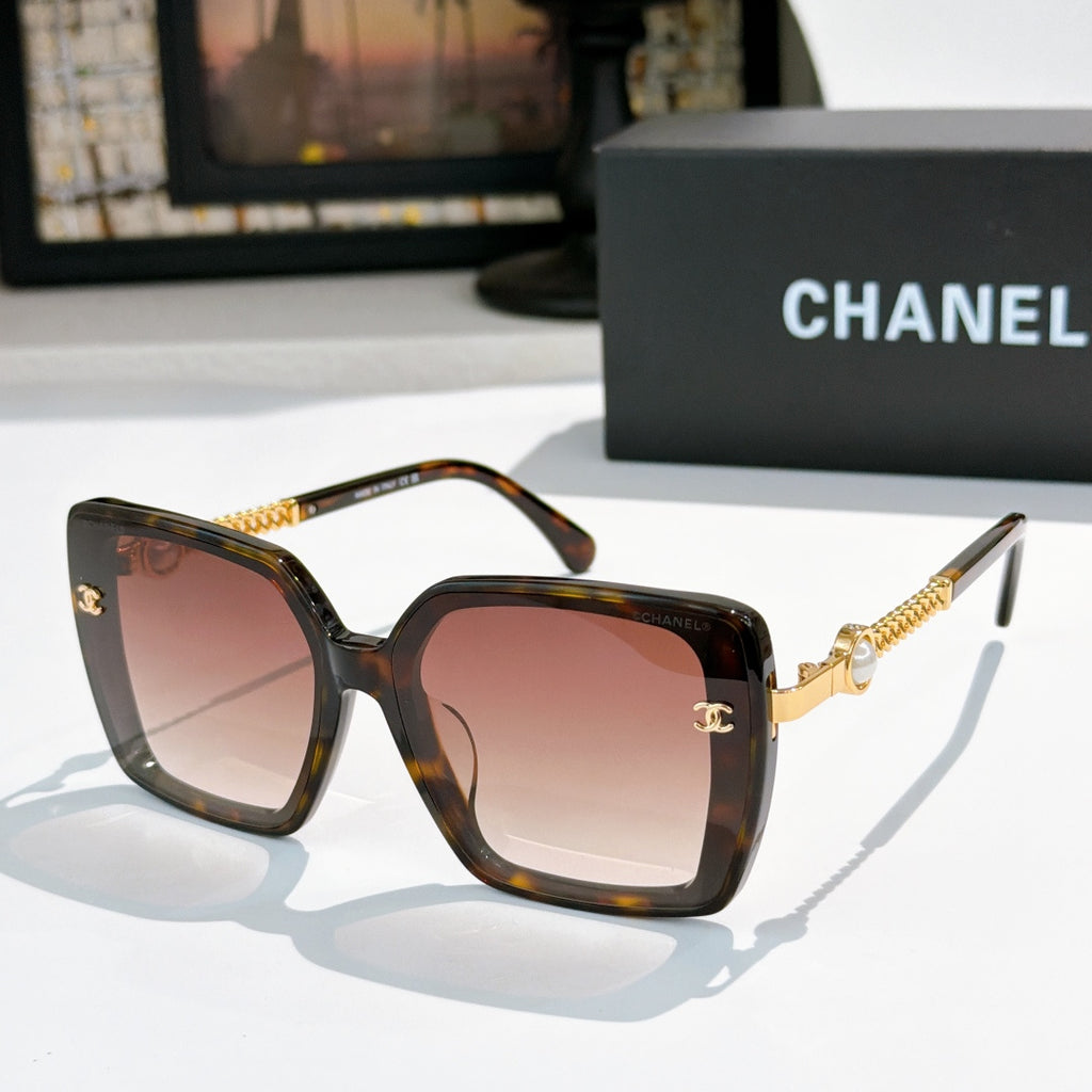 Dark tortoise square sunglasses with pink-tinted lenses and gold chain temples