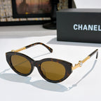Tortoiseshell sunglasses with amber lenses and gold chain detail on the temples.