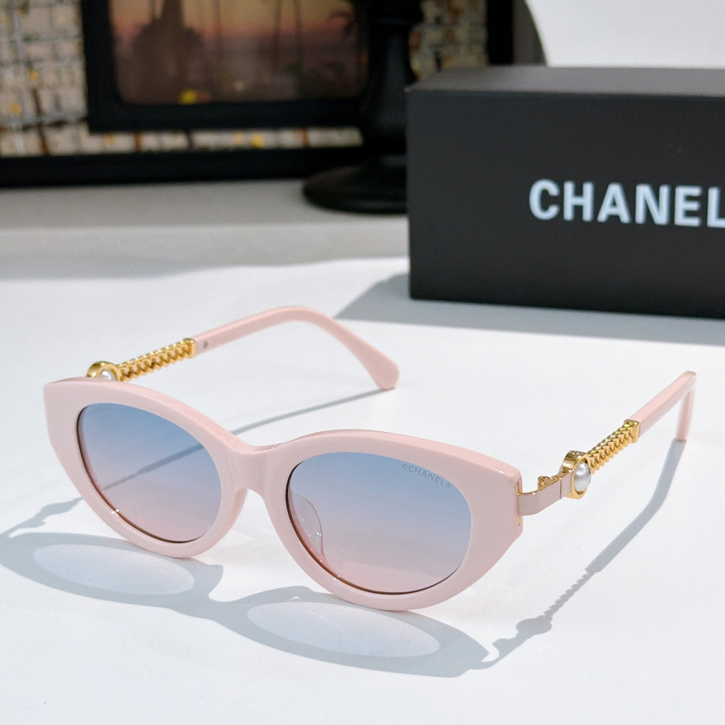 Pink cat-eye sunglasses with pale lenses and gold chain temples.