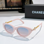 Pink cat-eye sunglasses with pale lenses and gold chain temples.