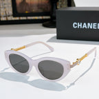 White sunglasses with dark lenses and gold chain temple detailing.