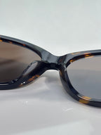 Gucci eyeglasses close-up of dark tortoise frame and tinted lens.