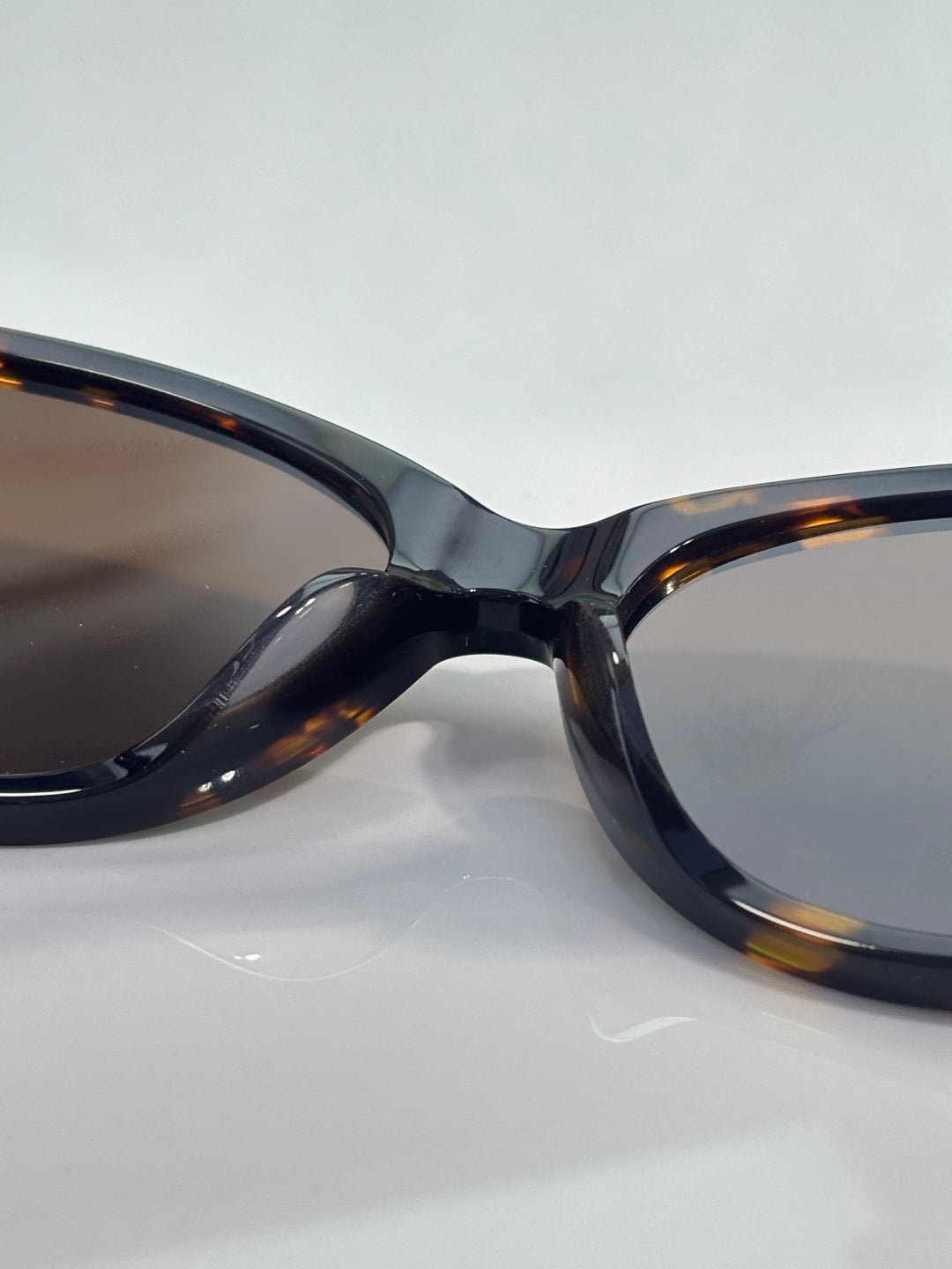 Gucci eyeglasses close-up of dark tortoise frame and tinted lens.