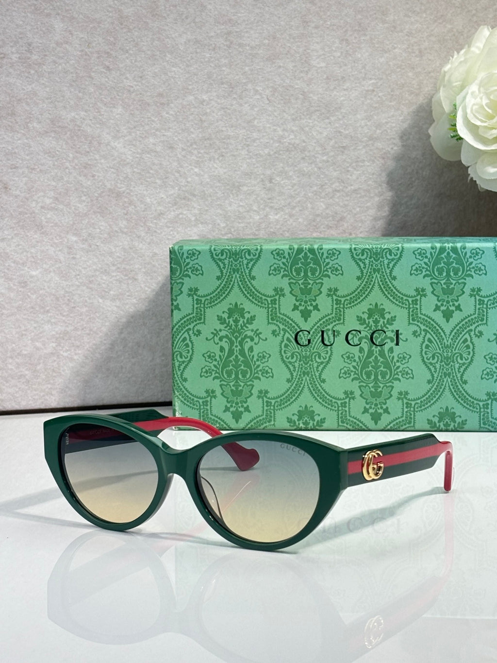 Gucci eyeglasses with green-and-red temple arms and tinted lenses, tortoise frame.