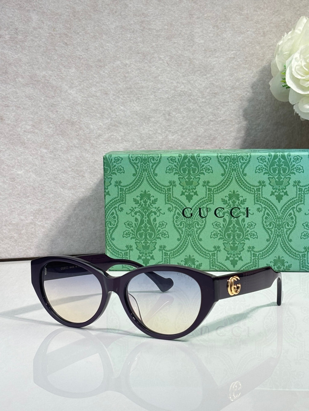 Gucci eyeglasses with dark tortoise frame and light-reflective lenses, gold emblem.