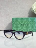 Gucci eyeglasses with dark tortoise frame and light-reflective lenses, gold emblem.