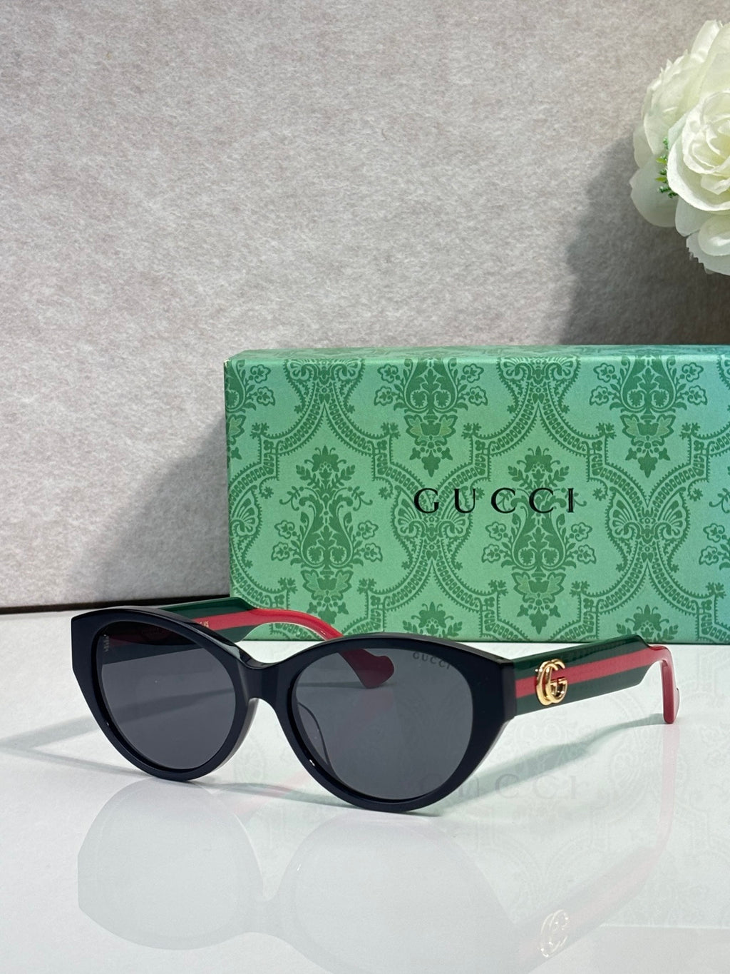 Gucci eyeglasses with black frame and dark lenses, gold logo on temple.