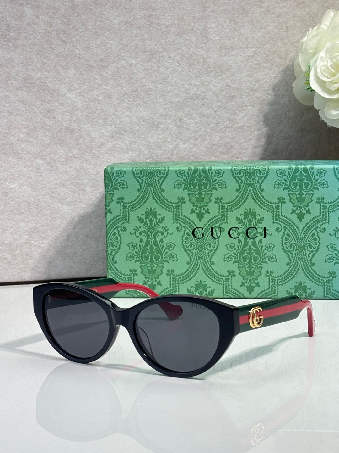 Gucci eyeglasses with black frame and dark lenses, gold logo on temple.
