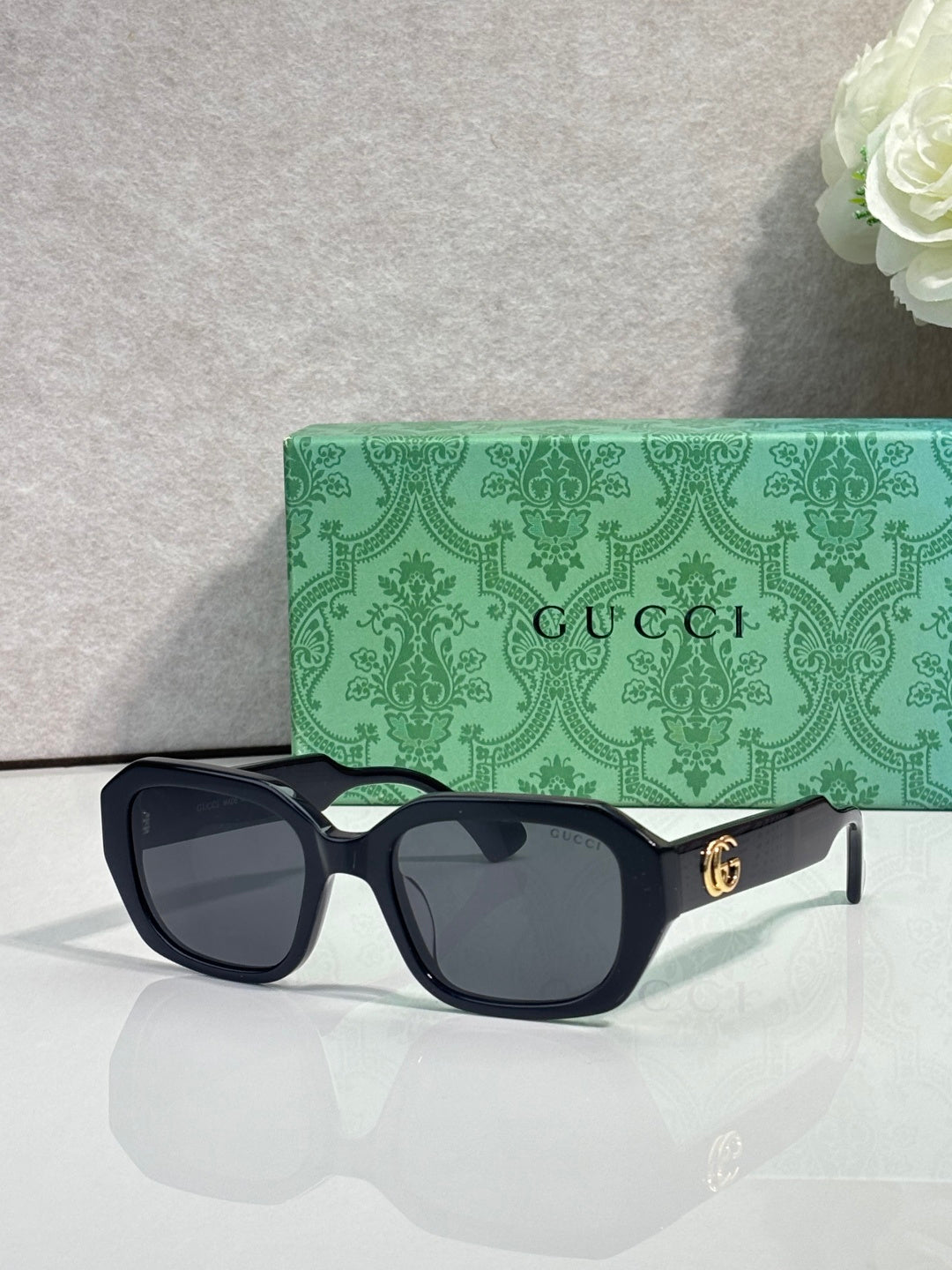 Gucci square sunglasses with dark frame and dark tinted lenses, gold logo temples