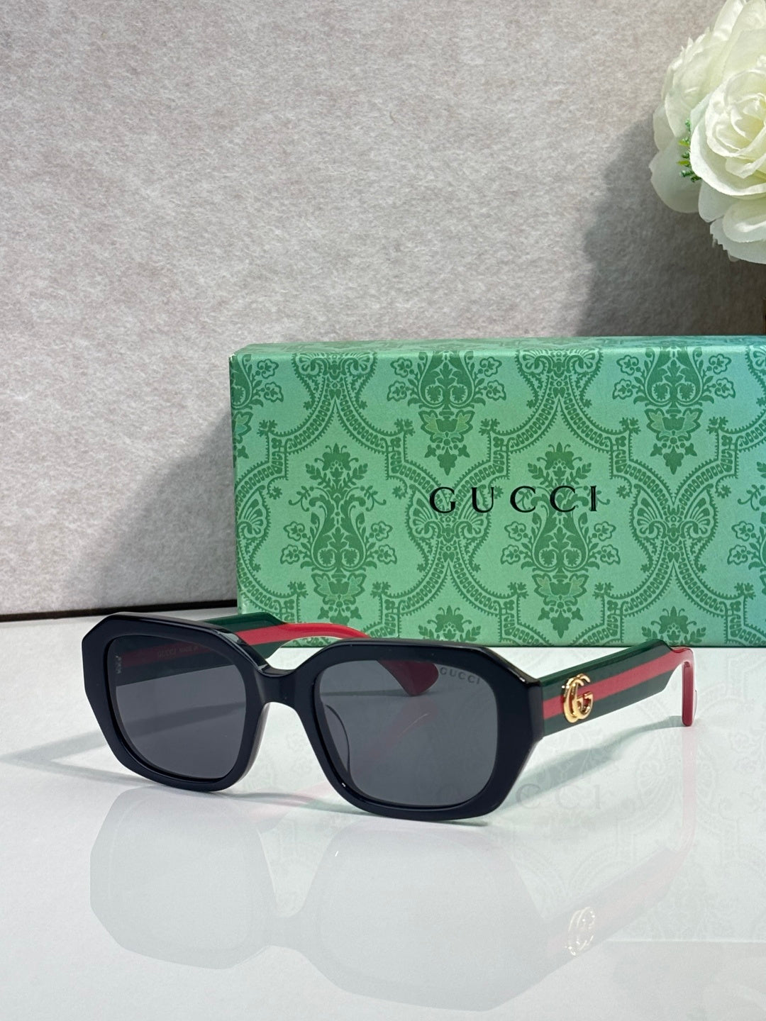 Gucci square sunglasses with dark frame and rounded corners, dark lenses, gold logo temples